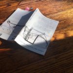 Photo courtesy Carolyn Hall: the Field Guide half in shadow, folded in half on wooden surface
