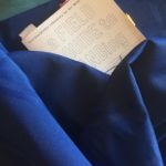 Photo by Carolyn Hall: The Field Guide nestled in a bed of blue fabric, the top half of the book's cover visible with some post-it's sticking out